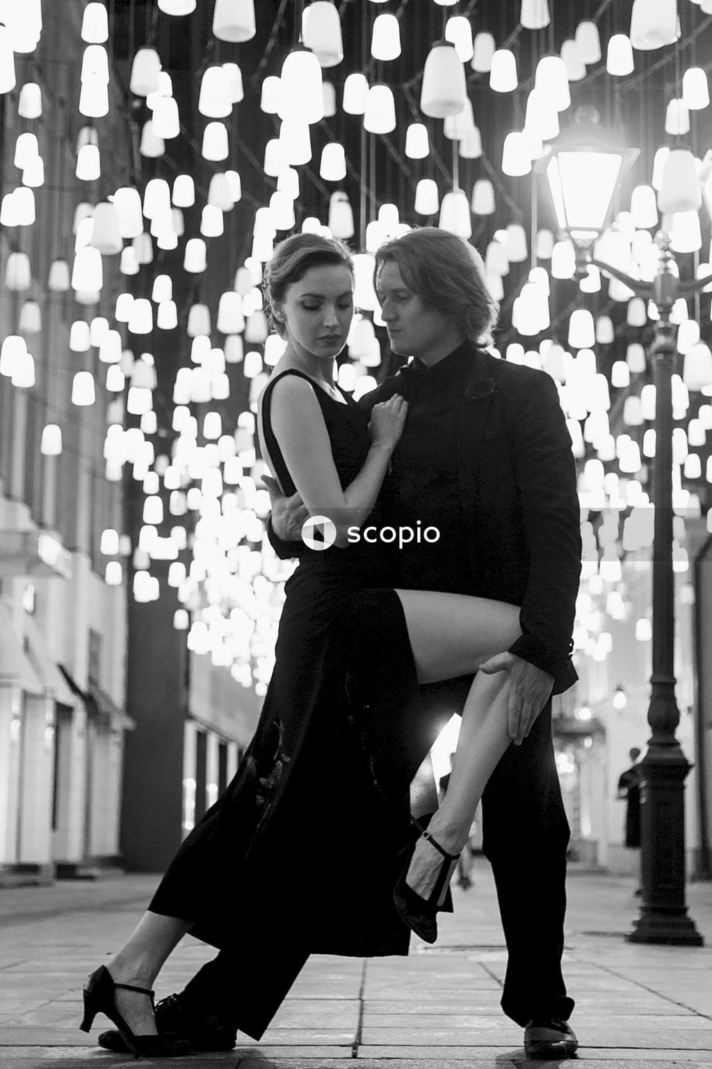 Grayscale photo of man and woman dancing tango outdoor