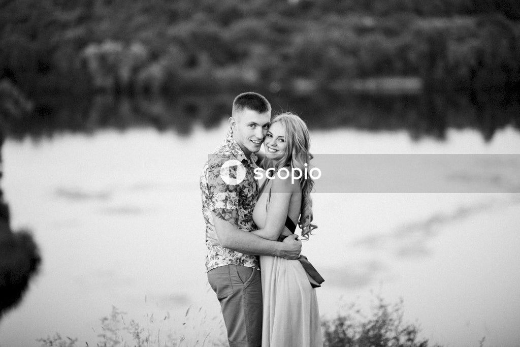 Grayscale photo of man and woman hugging each other
