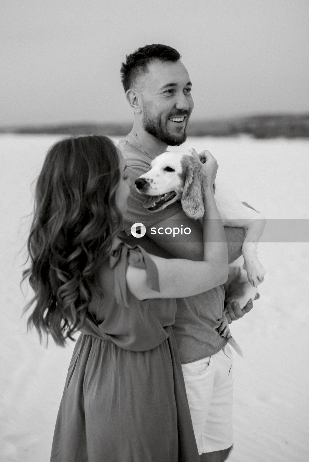 Grayscale photo of man hugging woman