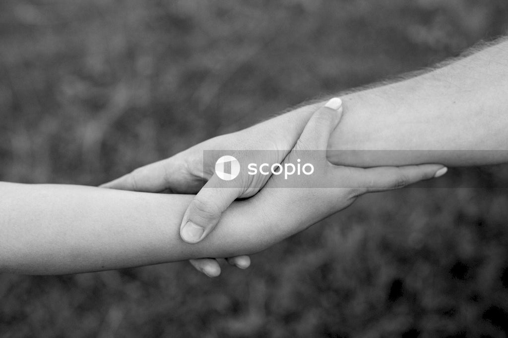 Grayscale photo of two hands holding