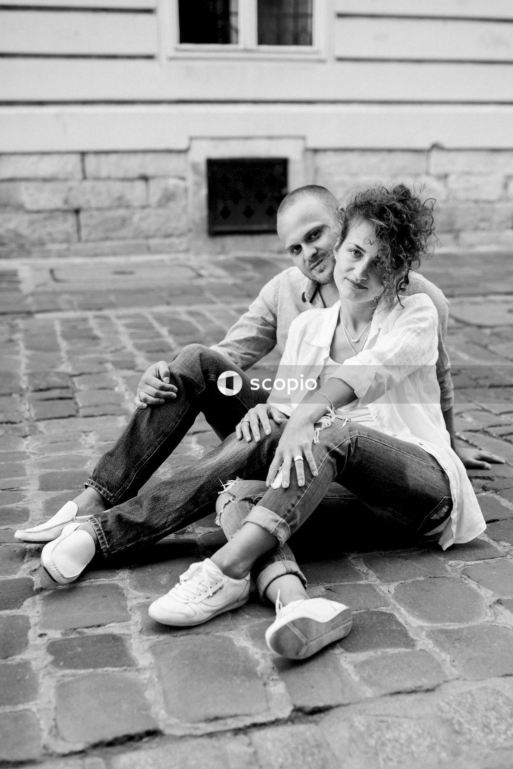 Grayscale photo of woman and man sitting on floor