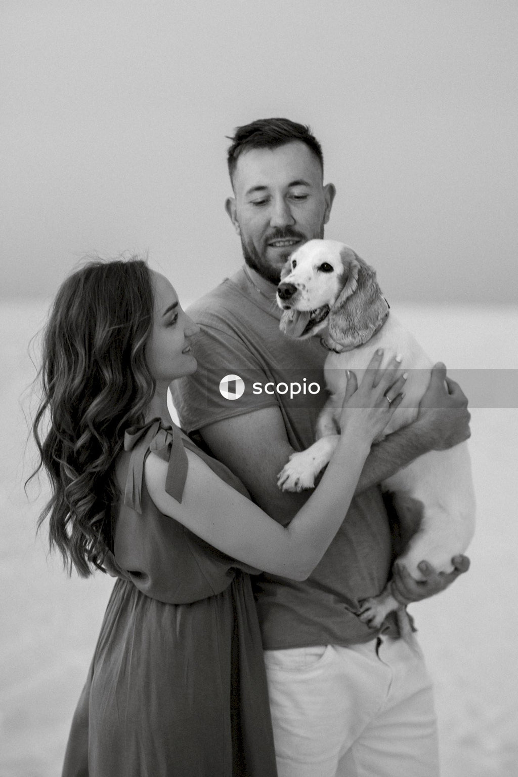 Grayscale photo of woman hugging dog