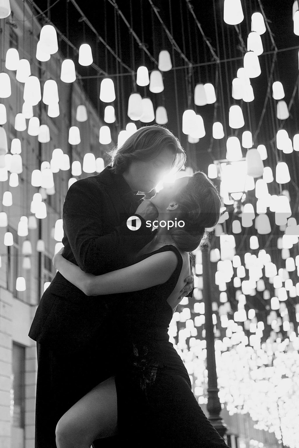 Grayscale photo of woman hugging man