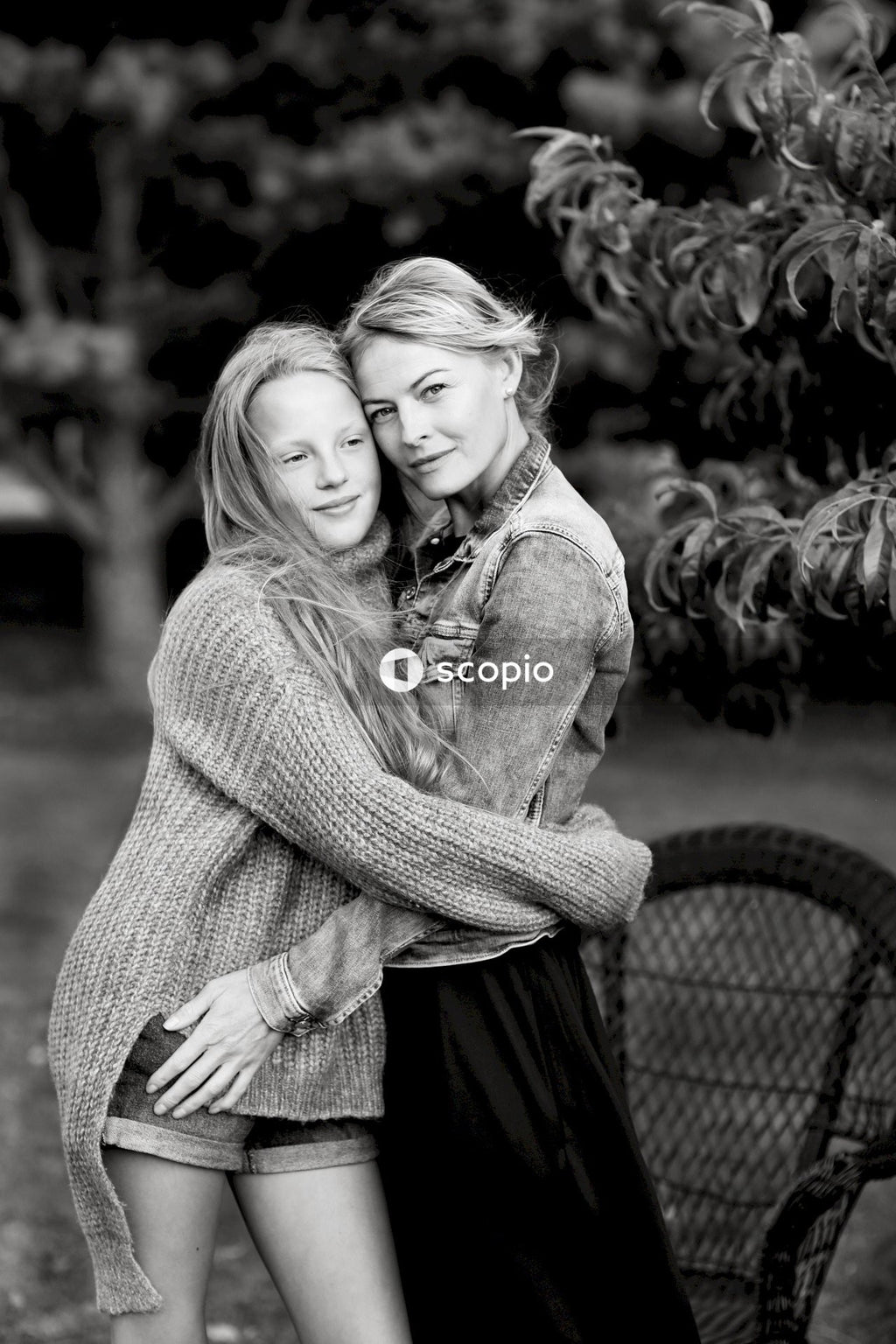 Grayscale photo of woman hugging woman