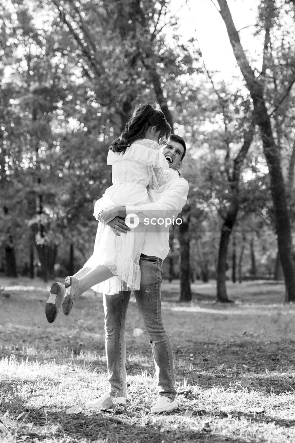 Grayscale photo of woman in white long sleeve shirt and gray pants hugging girl in white