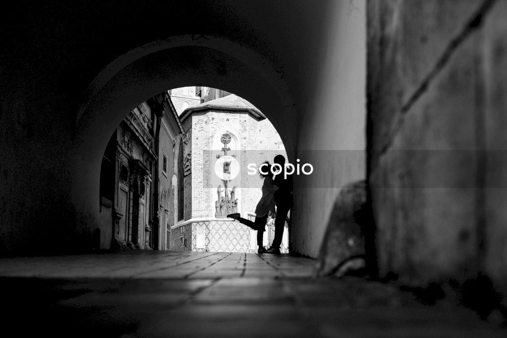 A Grayscale photo of a woman kissing a man in the street