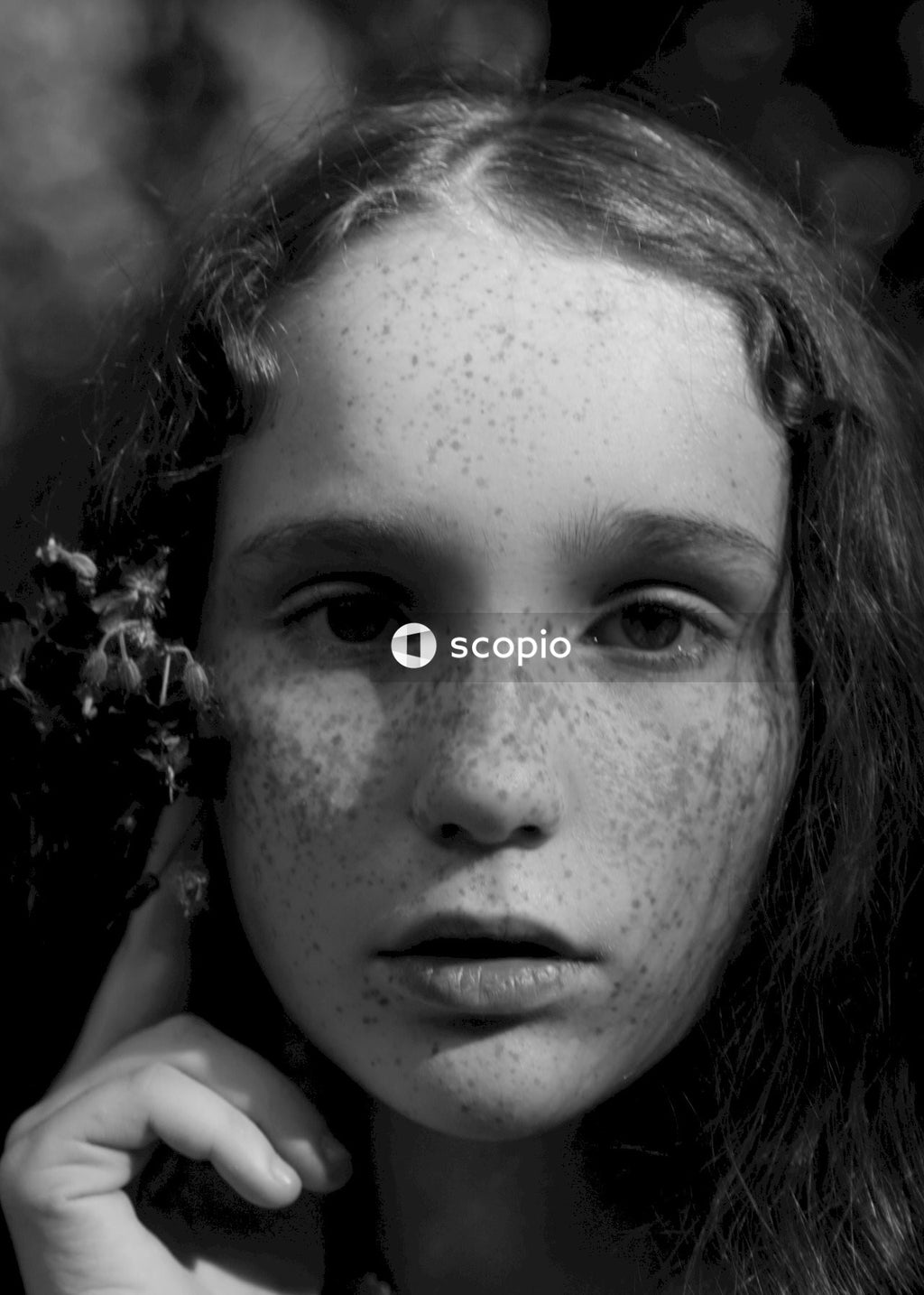 Grayscale photo of woman with flower on her ear