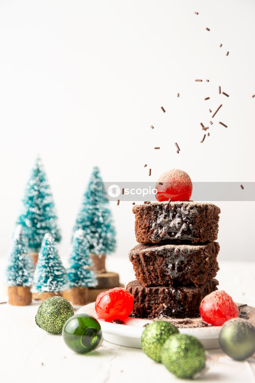 Green and brown chocolate cake with red round fruits
