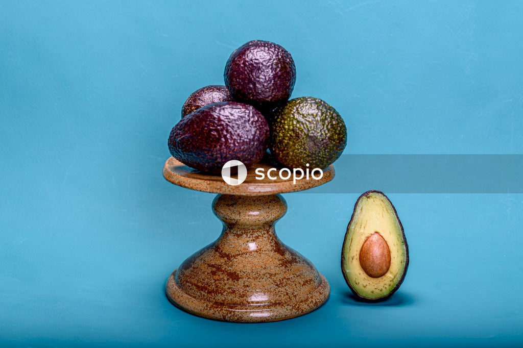 Green and brown fruit on brown ceramic vase