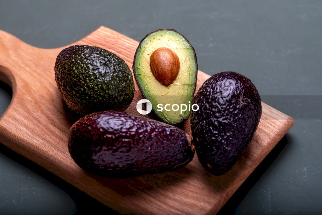 Green and brown fruit on brown wooden chopping board