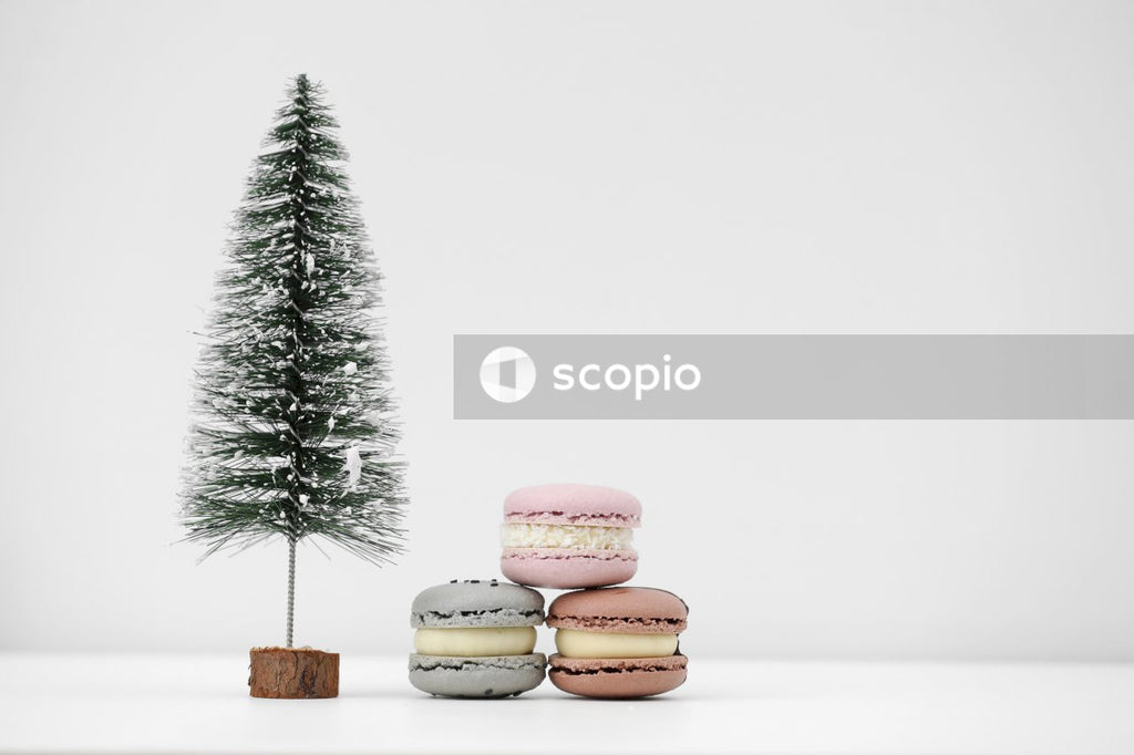 Green and pink macaroons on brown wooden chopping board