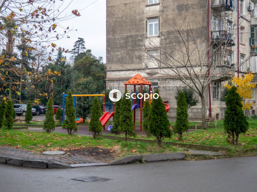 Green and yellow playground near brown concrete building