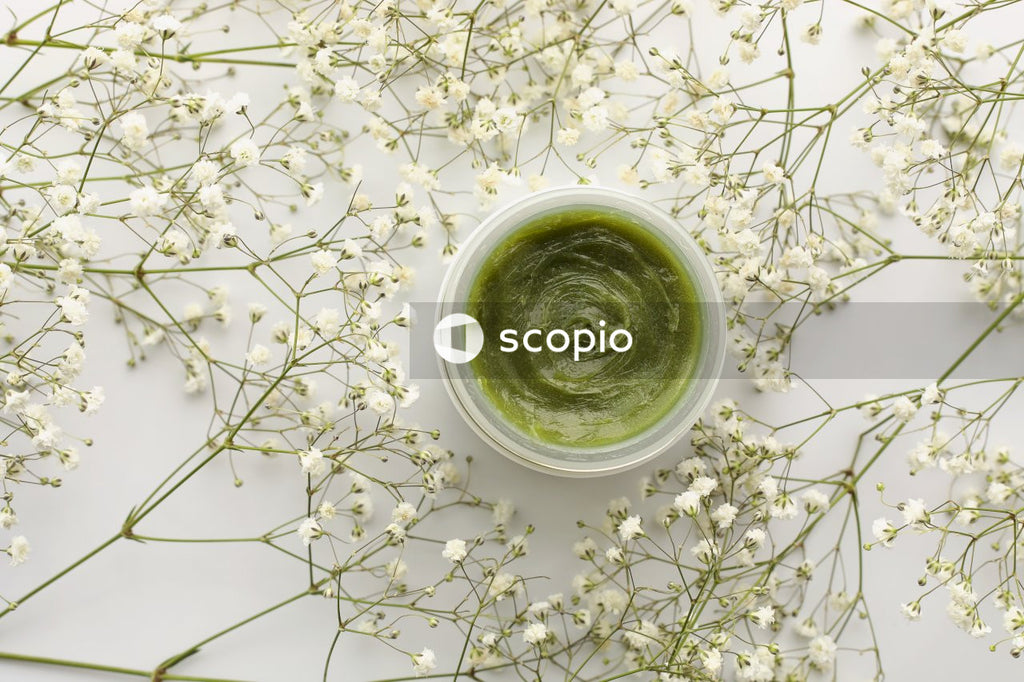 Green ceramic cup on white and brown floral textile