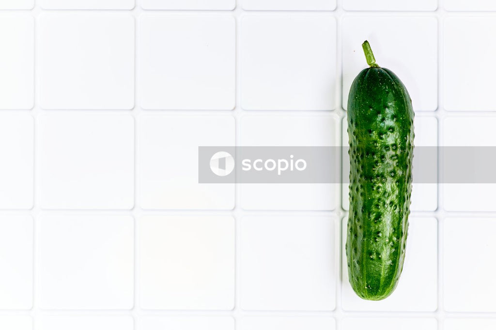 Green cucumber on white paper