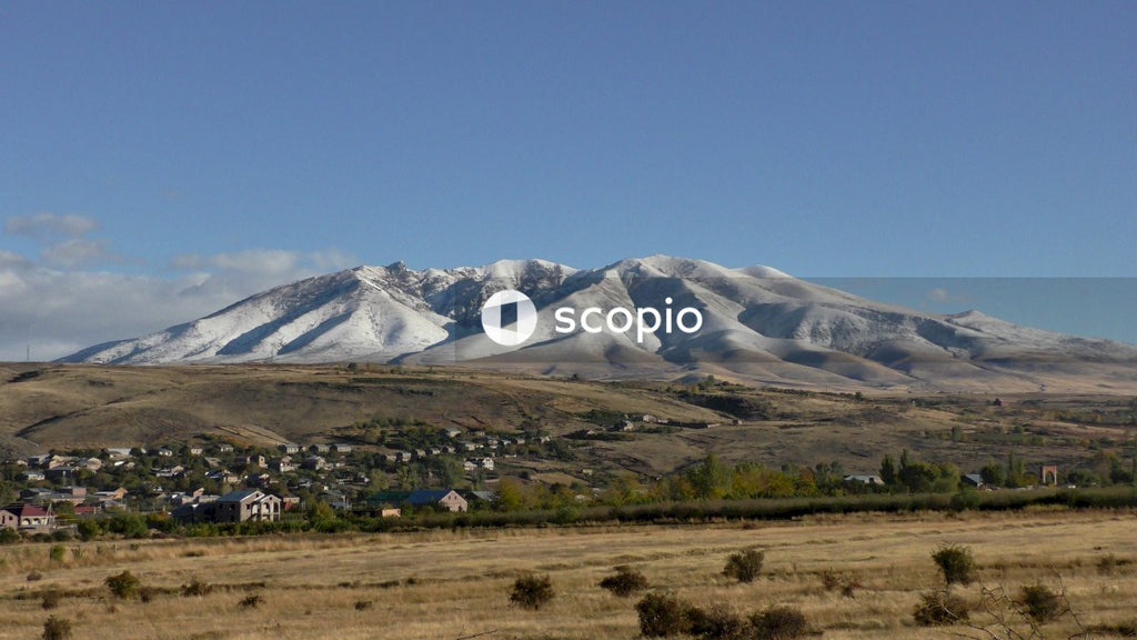 Green grass field near snow covered mountain