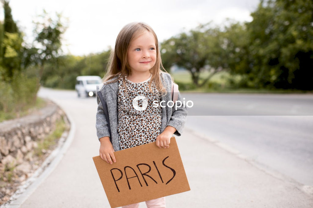 Happy smiling child girl 3-4 year old hold paper craft board card with copy space outdoors. Happiness. Little kid toddler have fun with poster. Summer vacation time