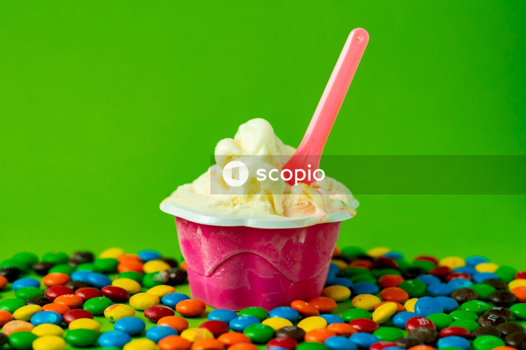 Ice cream on pink plastic cup with white plastic spoon