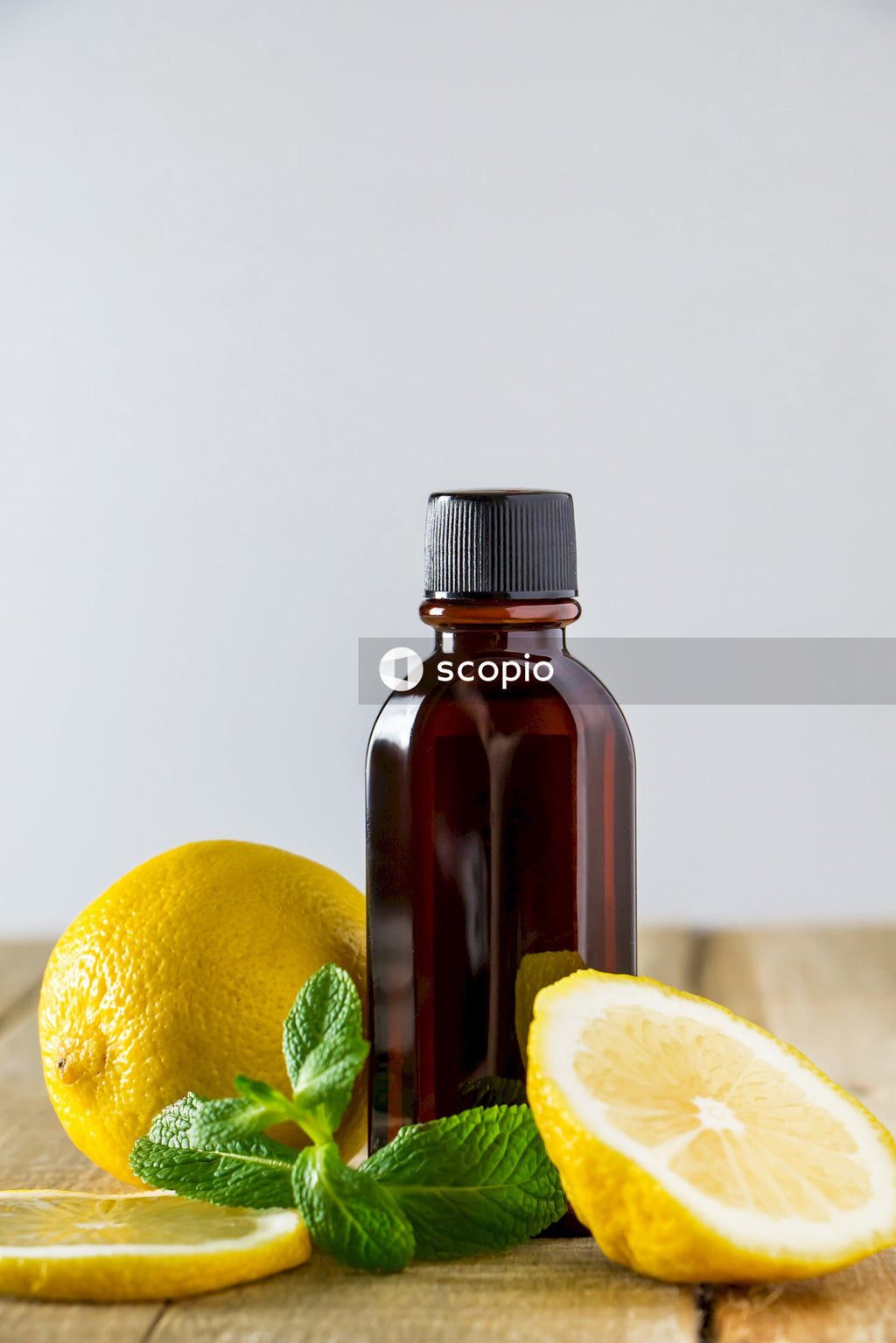 Lemon fruit beside brown glass bottle