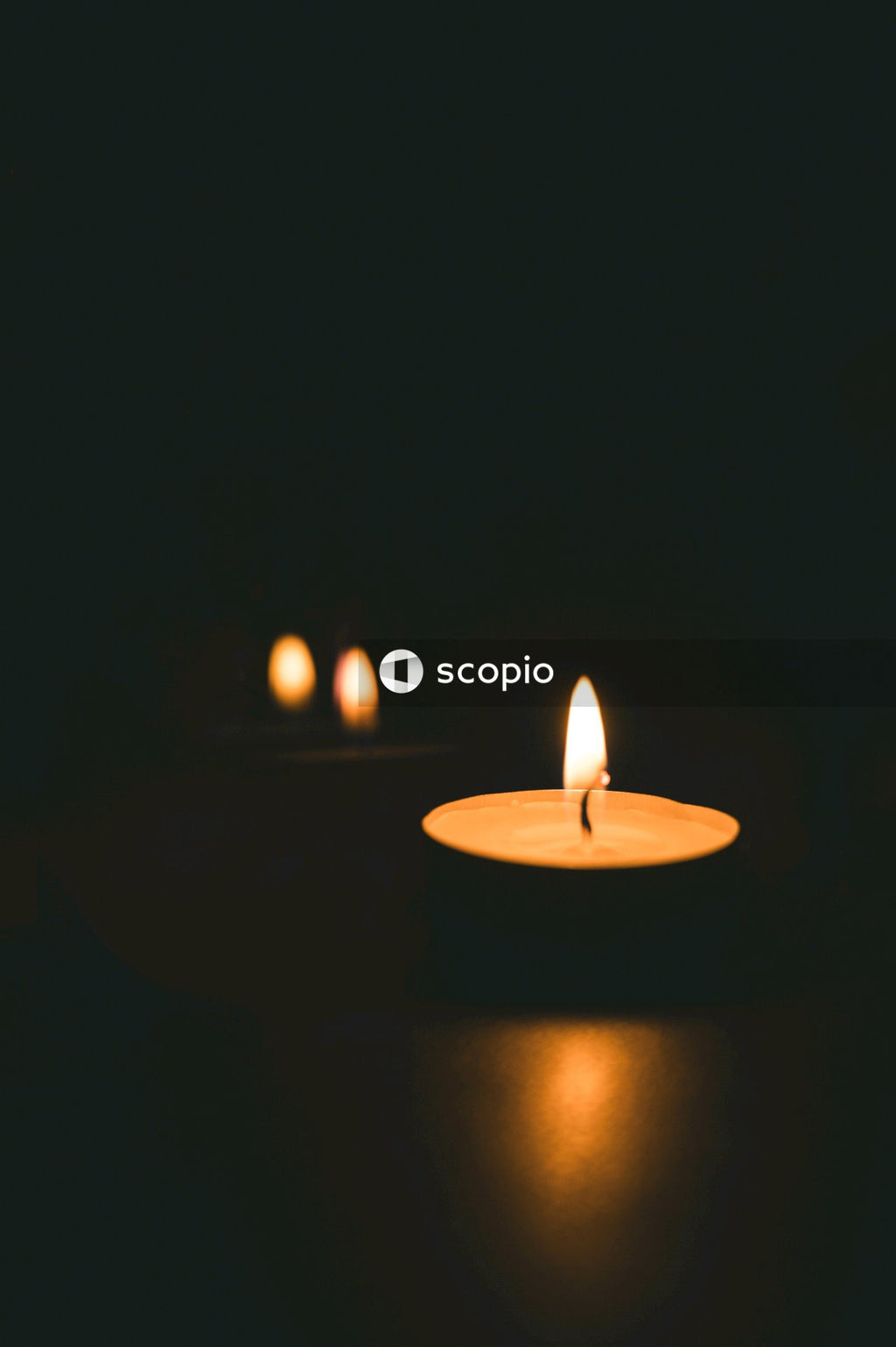 Lighted candle in dark room