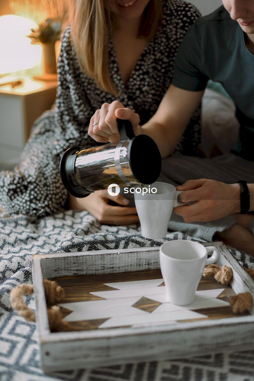 Man and a woman drinking tea in their bedroom