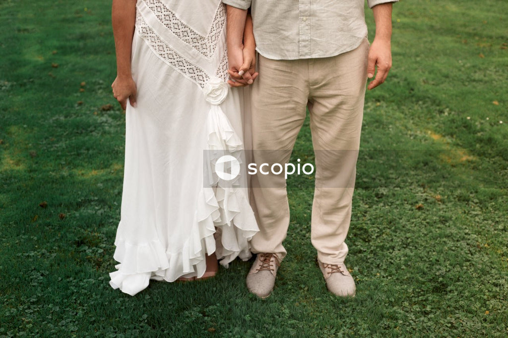 Man and woman standing on grass and holding hands