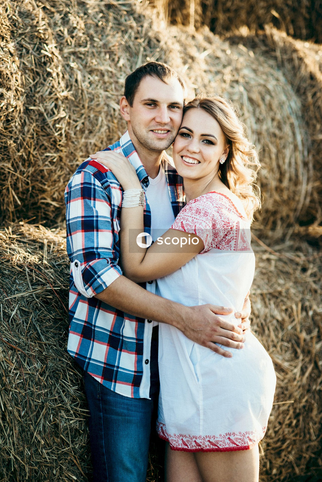 Man and woman hugging on brown grass field