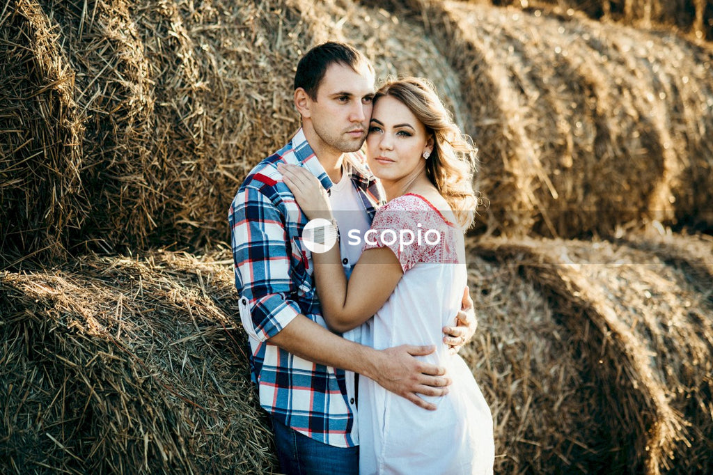 Man and woman hugging on brown grass field