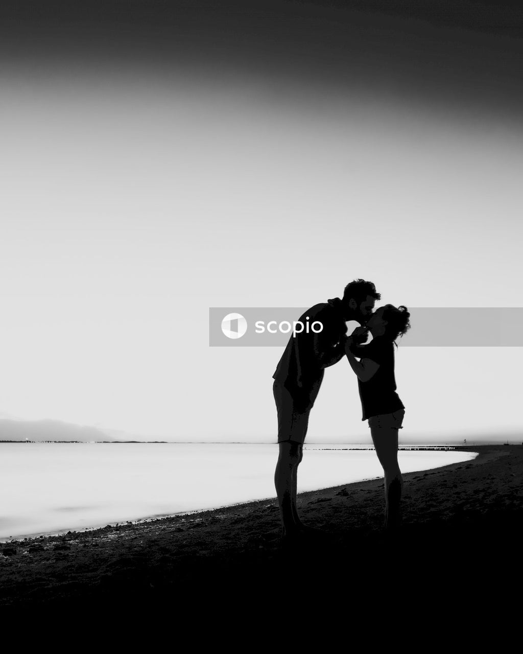 Man and woman kissing on beach shore
