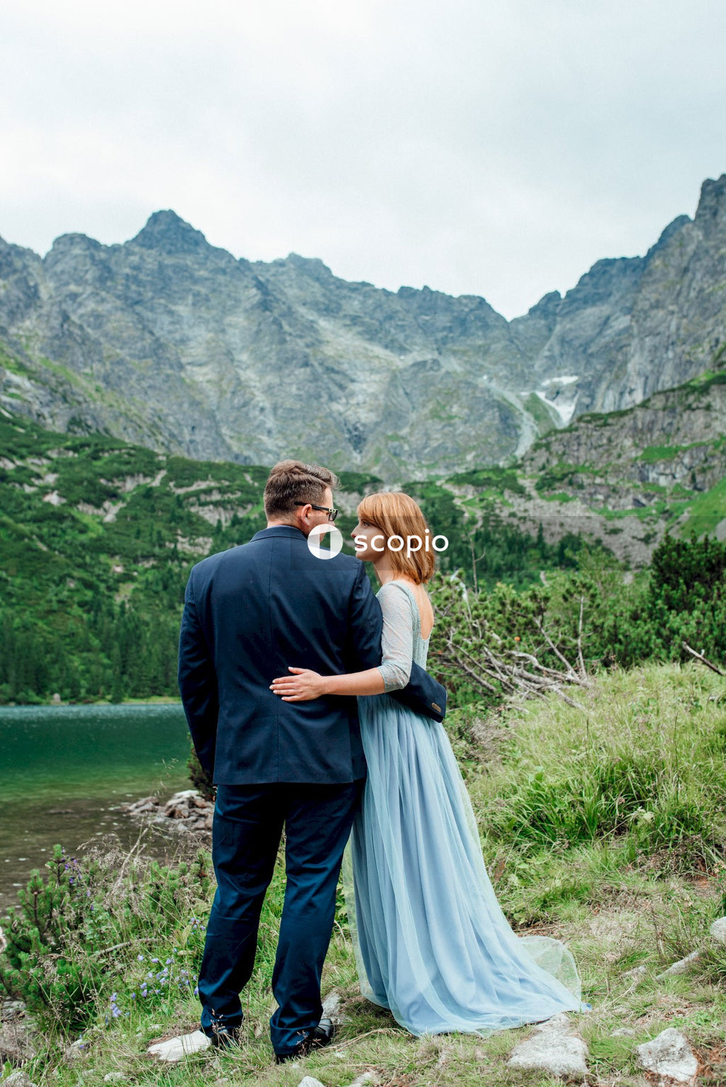 Man and woman kissing on green grass field