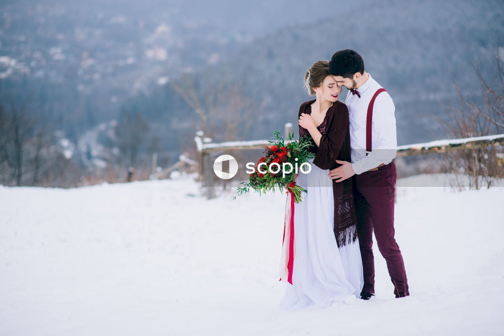 Man and woman kissing on snow covered ground