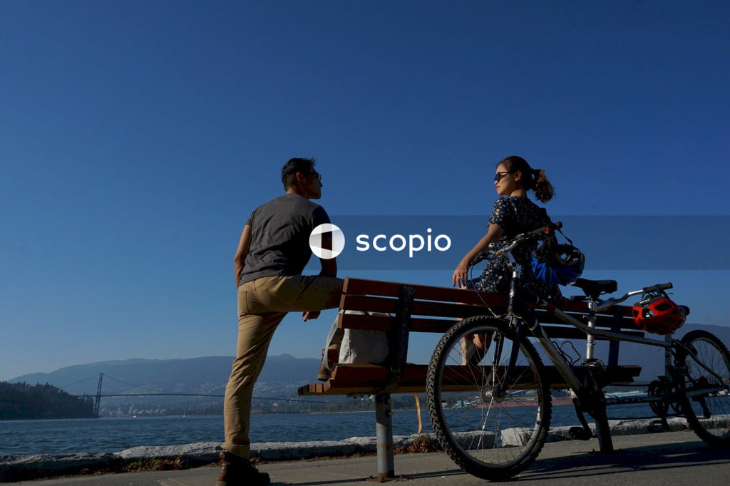 Man and woman sitting on bench near beach