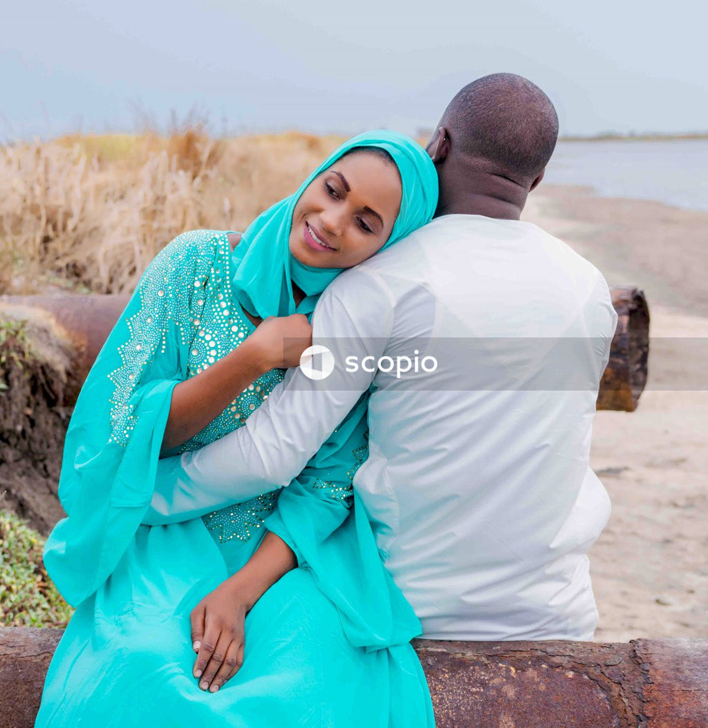 Man and a Muslim woman hugging each other at the beach