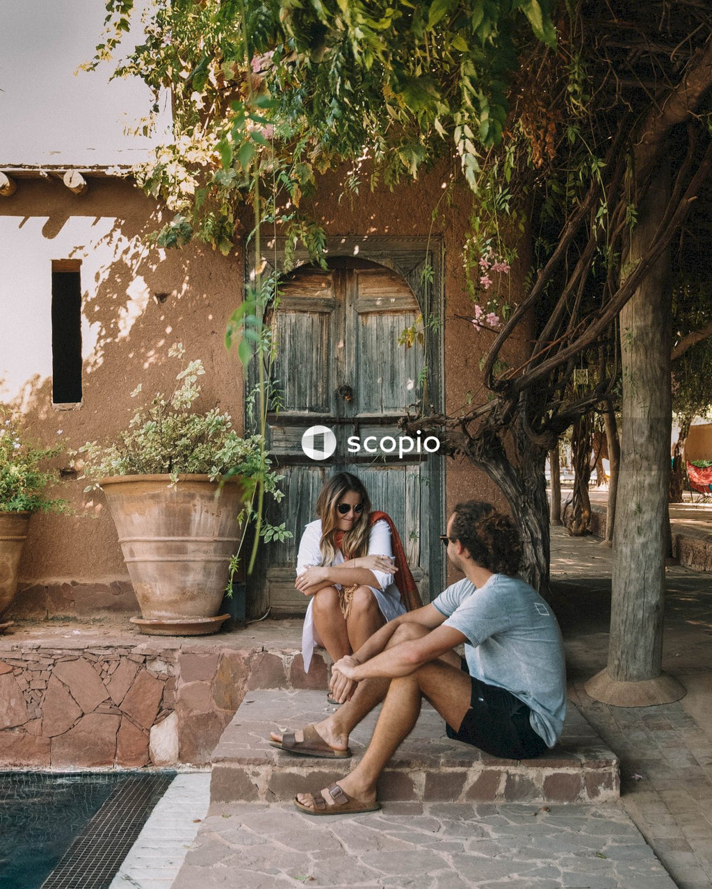 Man and woman sitting on stairs in front of a house