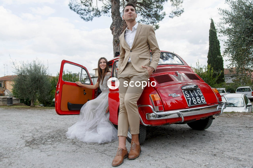 Young married couple doing a photoshoot near small red car