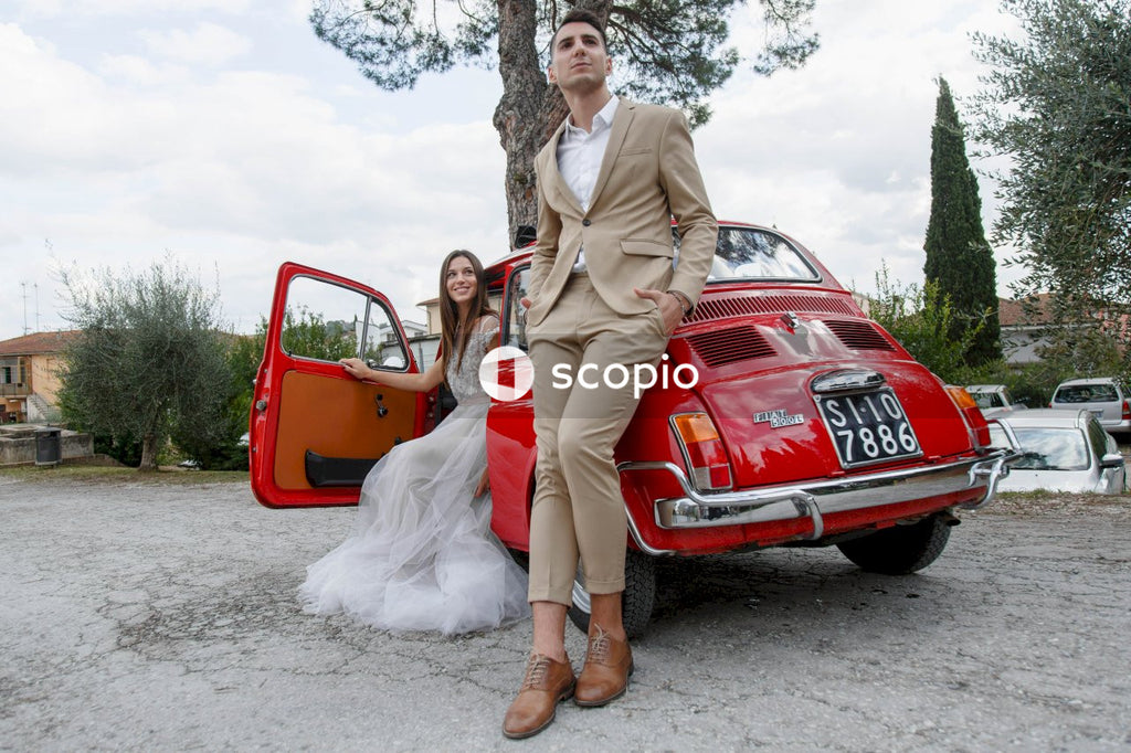 Young married couple doing a photoshoot near small red car