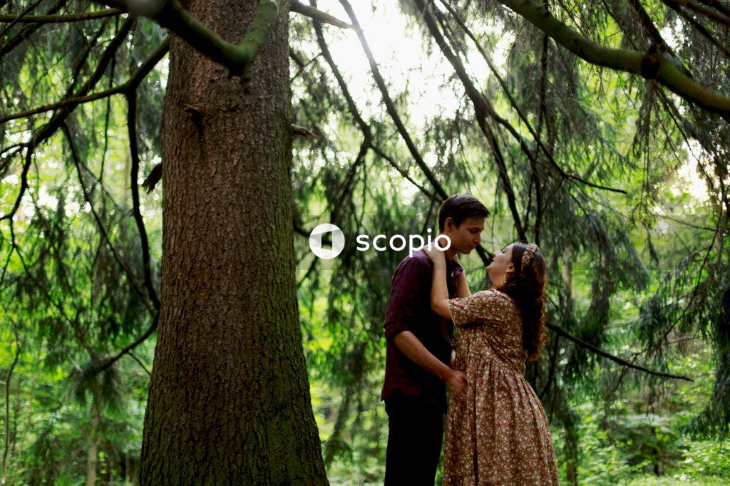 Man and woman standing beside tree