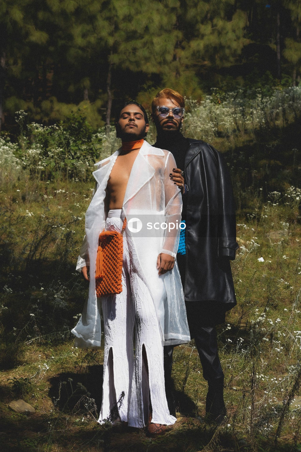 Two genderqueer man in stylish outfits having romantic moments outdoor in the nature