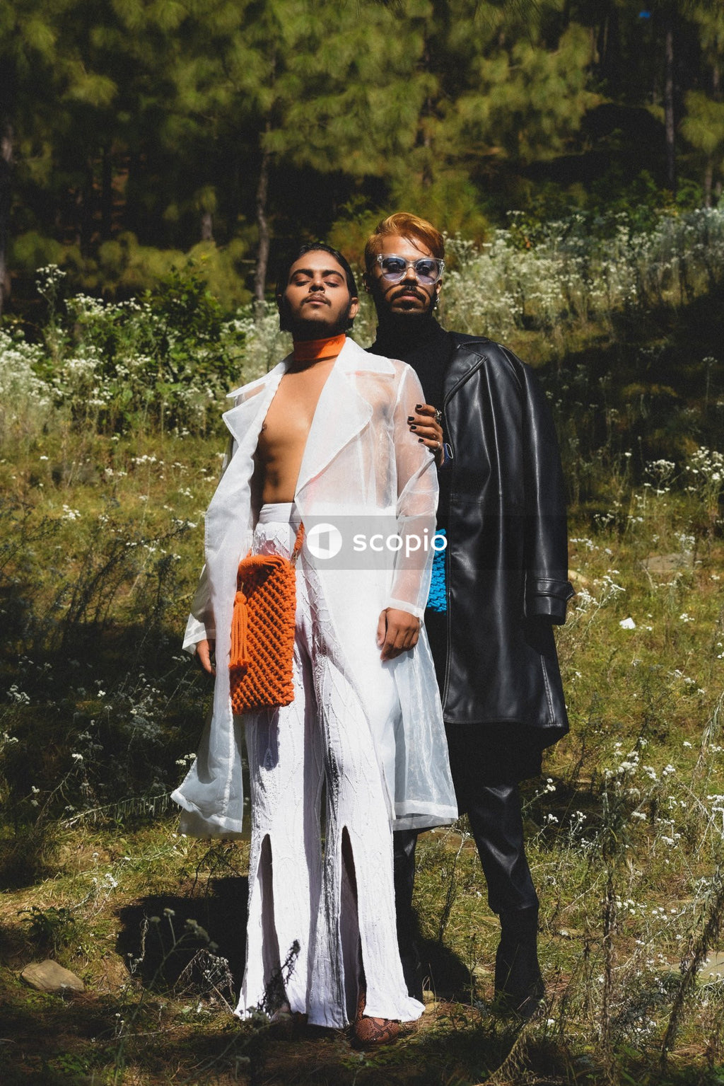 Two genderqueer man in stylish outfits having romantic moments outdoor in the nature