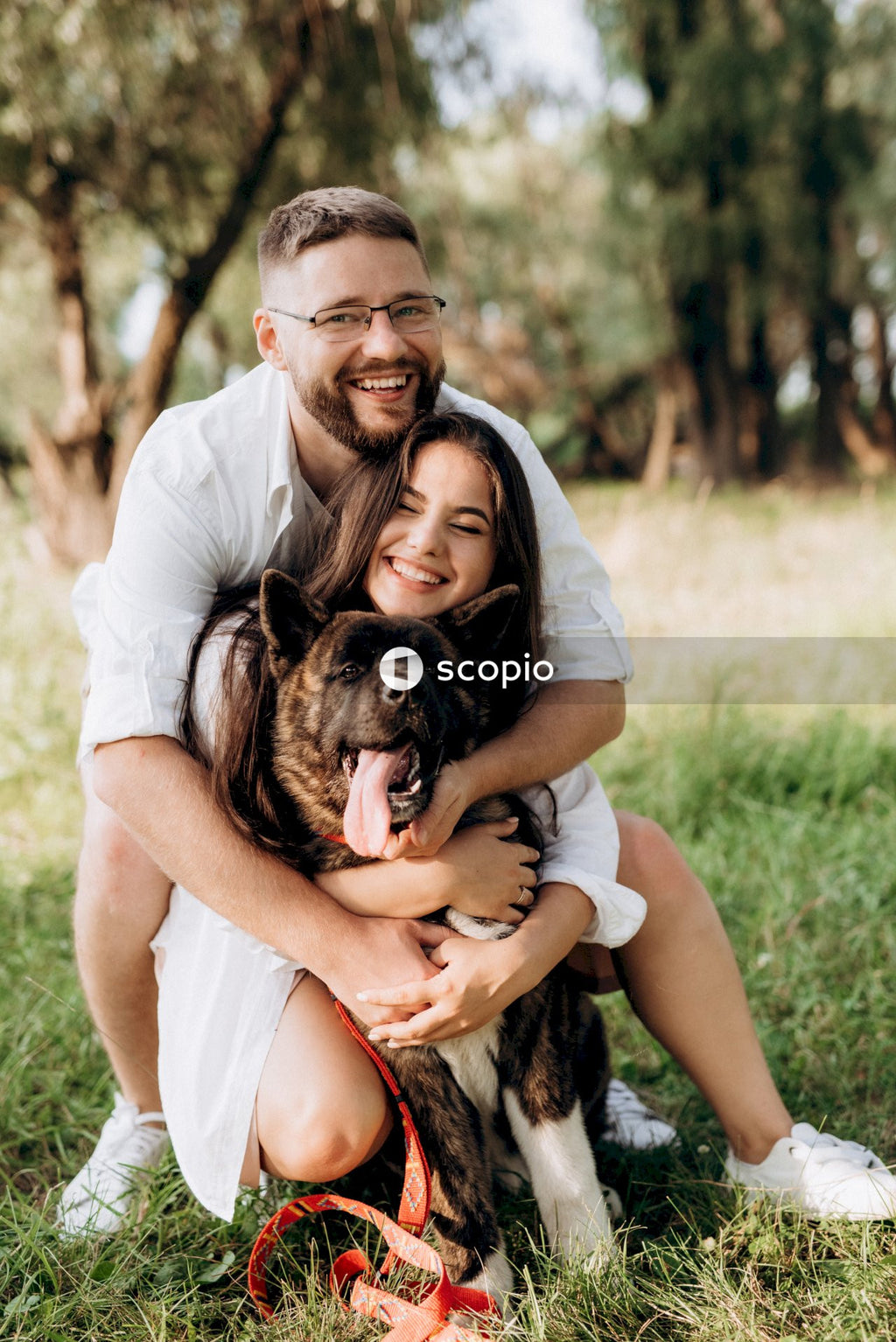 Man hugging black and brown short coated dog
