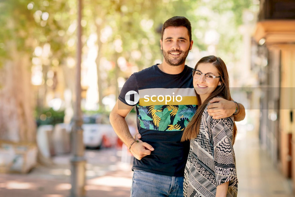 Man in black crew neck t-shirt hugging woman in black and white dress