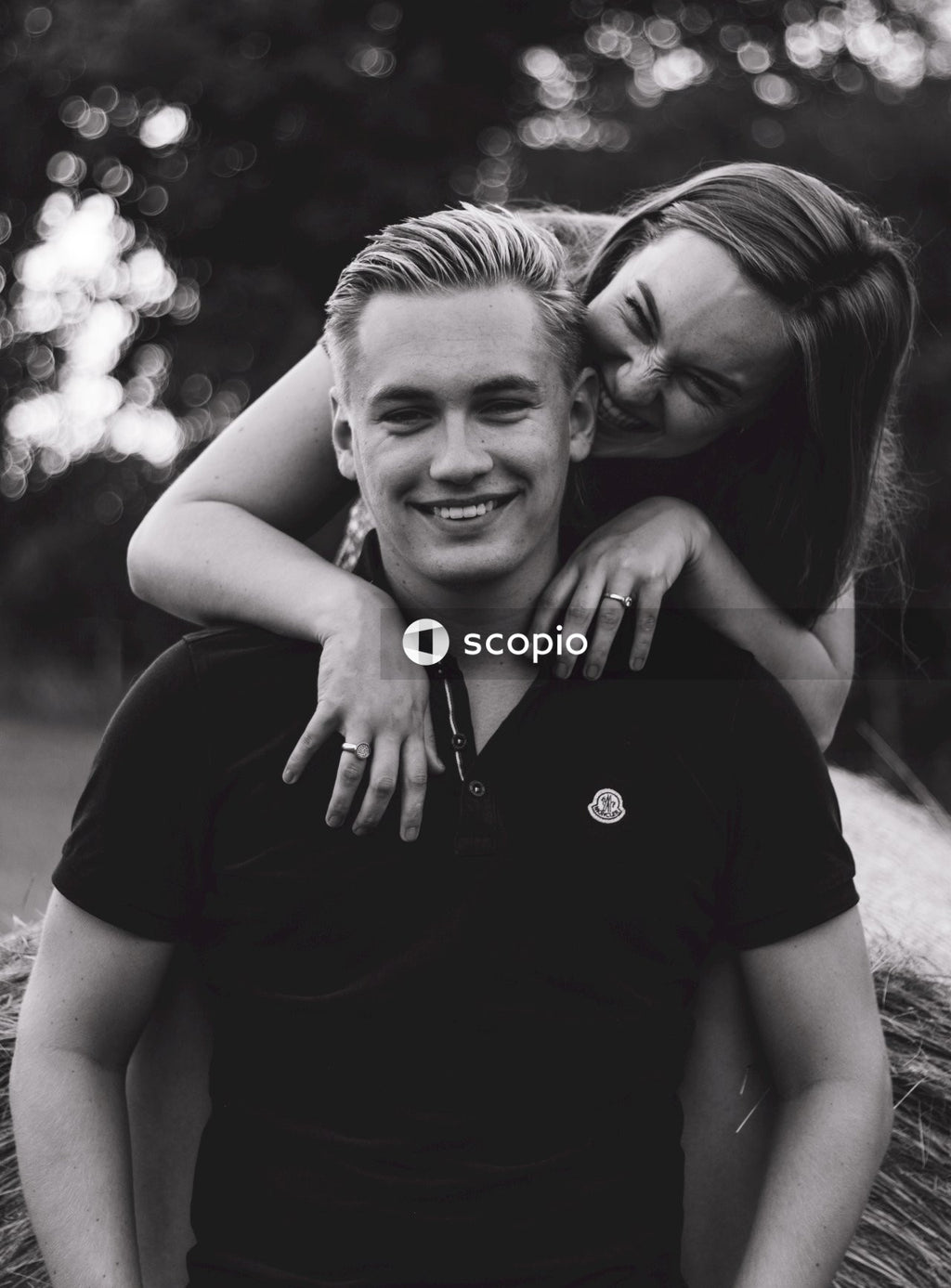 Man in black crew neck t-shirt hugging woman in black t-shirt