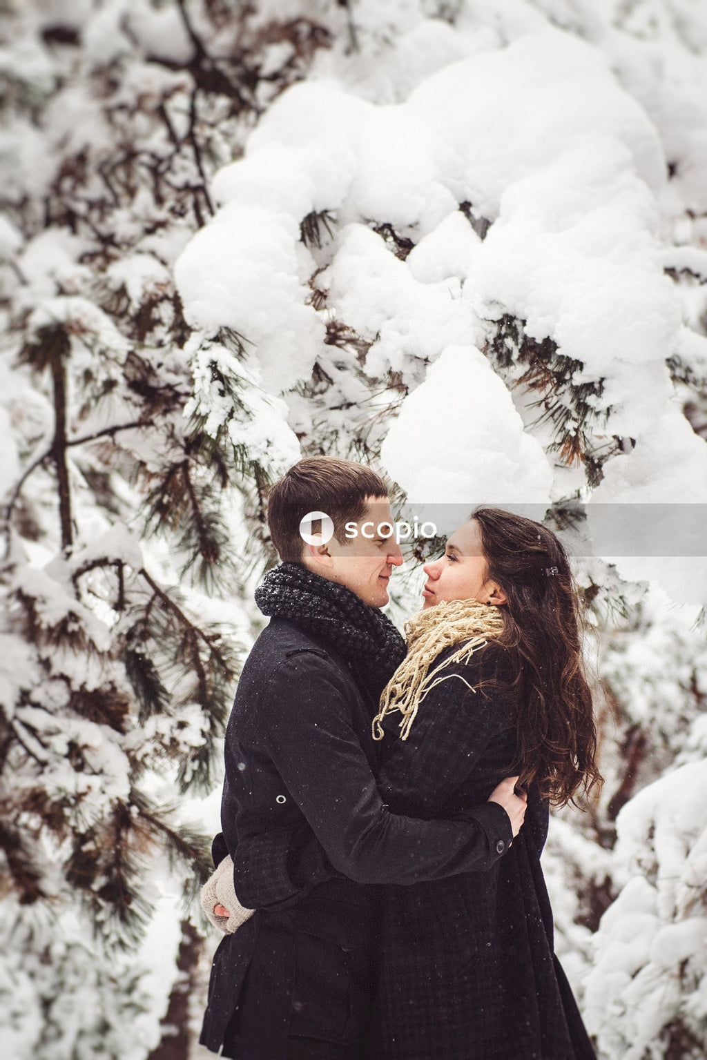 Man in black jacket hugging woman in black jacket