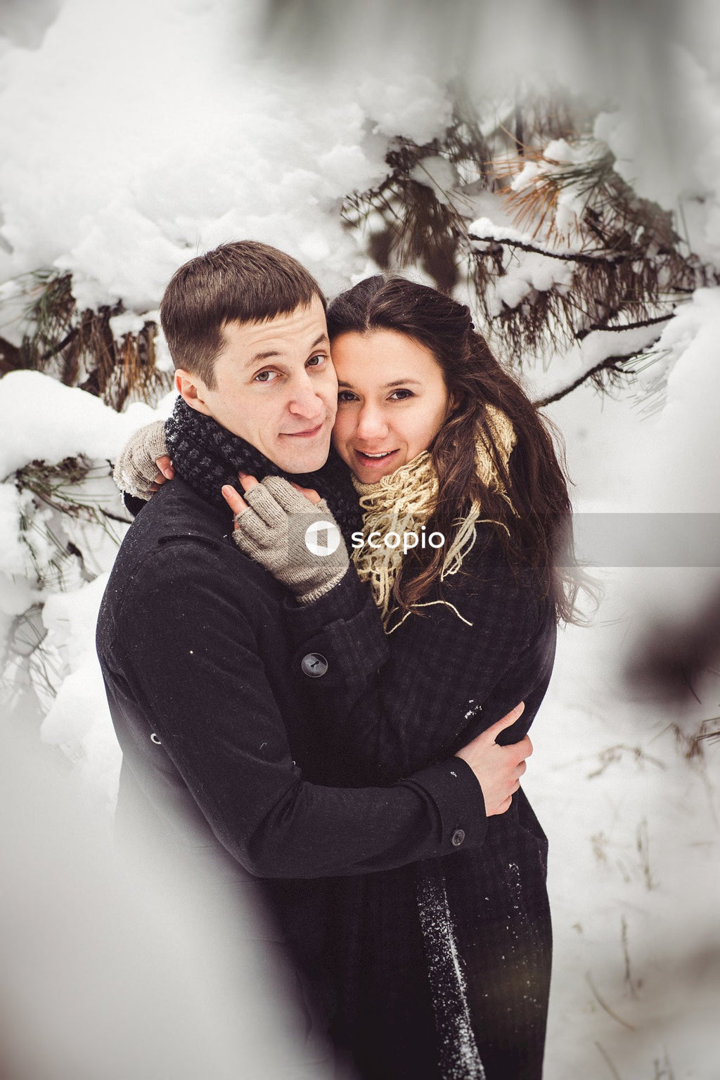 Man in black jacket hugging woman in black jacket