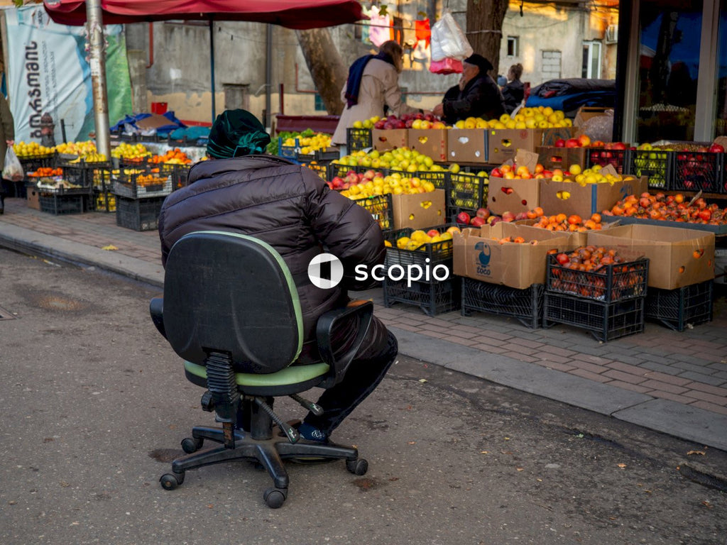 Man in black jacket sitting on green and black office rolling chair