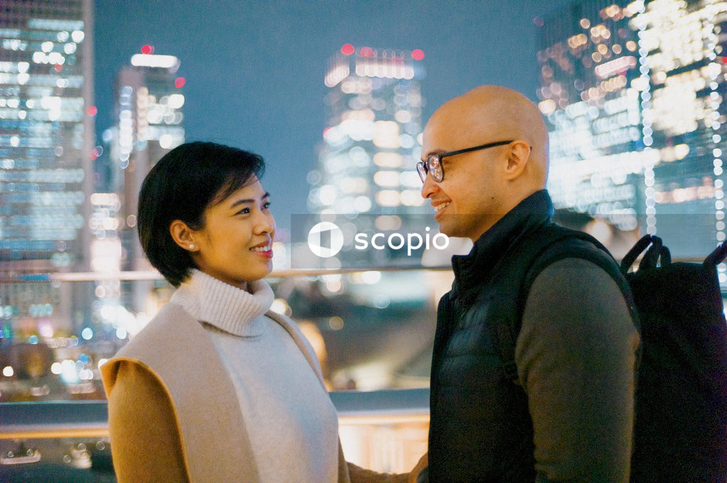 Man standing beside woman  in the city at nighttime