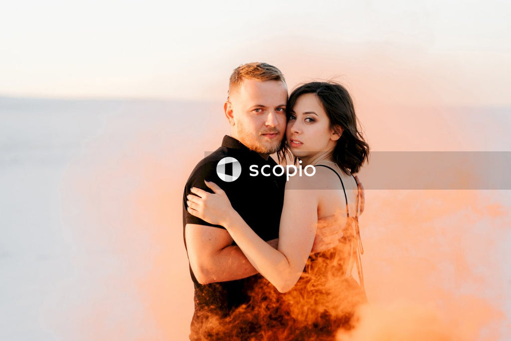 Man in black shirt hugging woman in white tank top