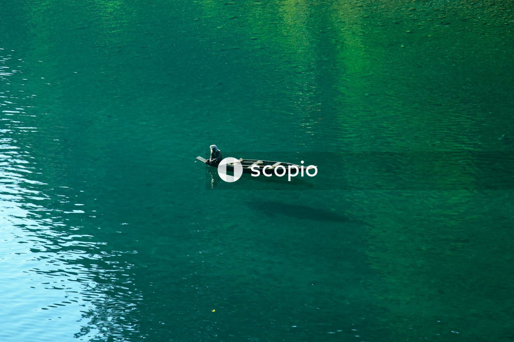 Man in black shirt riding on white and black boat on body of water