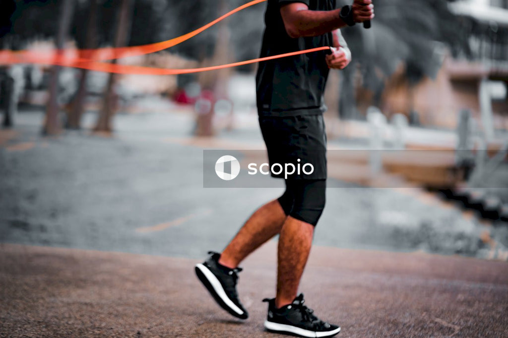 Man in black shorts and black nike shoes running on track field