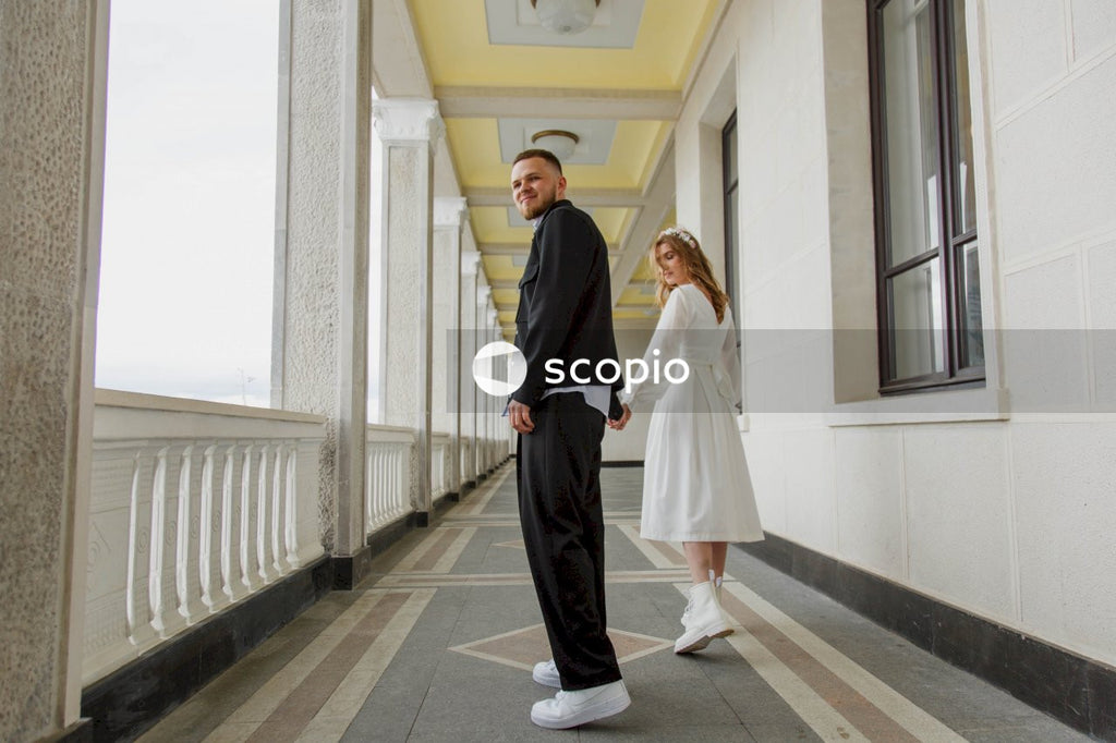 Man in black suit holding woman in white dress