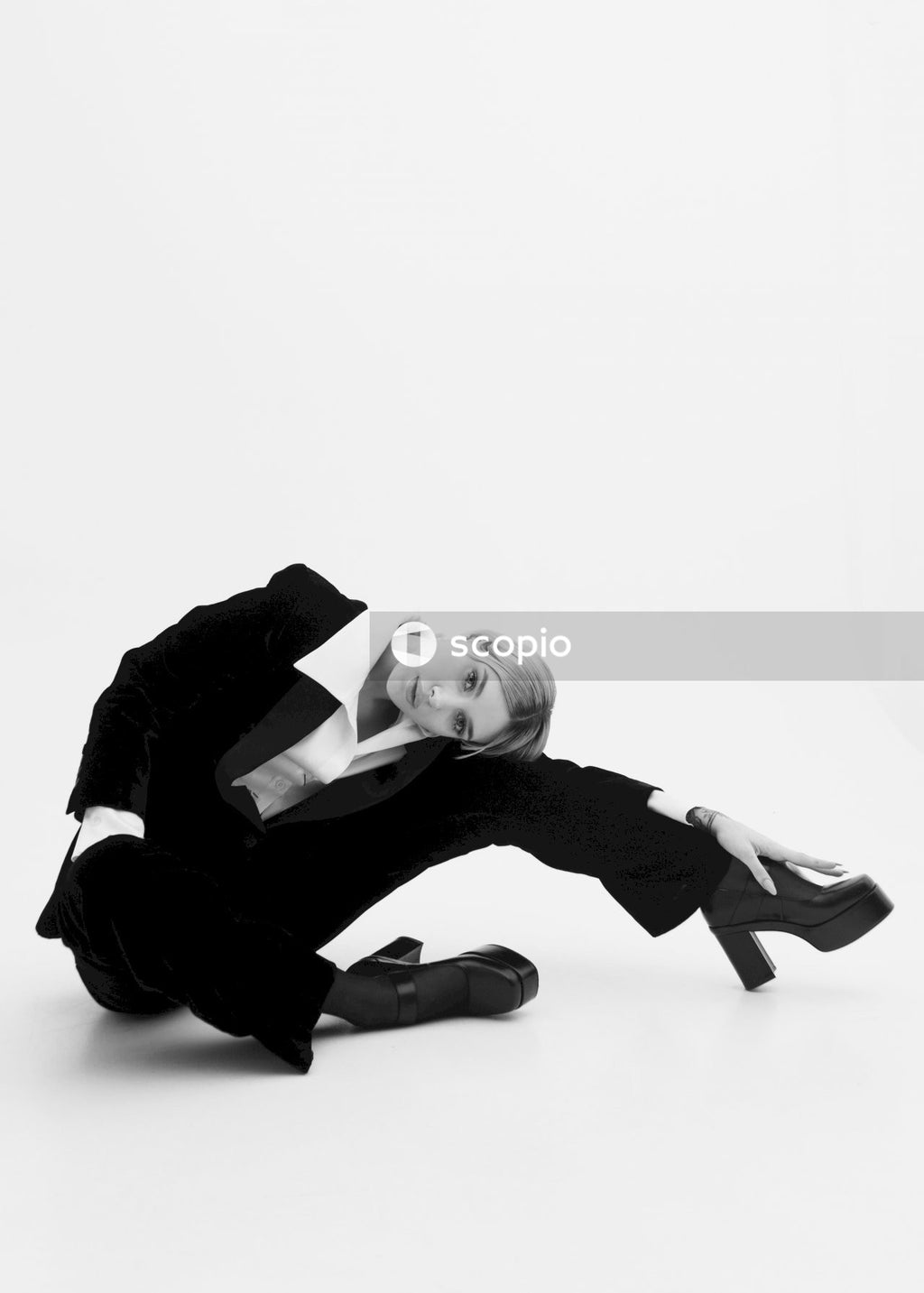 Man in black suit jacket and black pants lying on floor